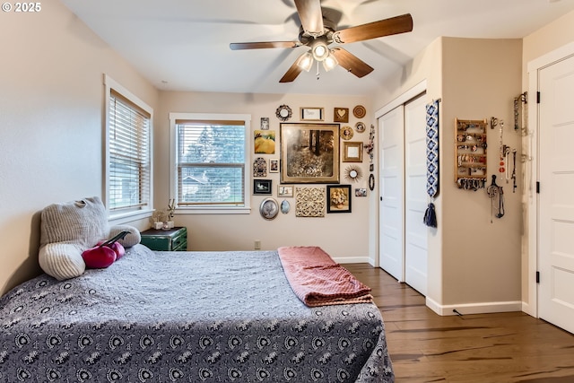 bedroom featuring a closet, baseboards, dark wood-style floors, and a ceiling fan