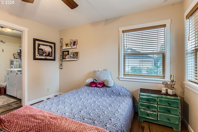 bedroom featuring water heater, independent washer and dryer, baseboards, and multiple windows