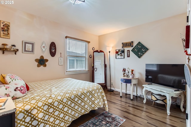 bedroom featuring baseboards and wood finished floors