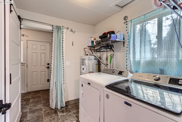 clothes washing area featuring washing machine and clothes dryer, laundry area, stone finish floor, and electric water heater