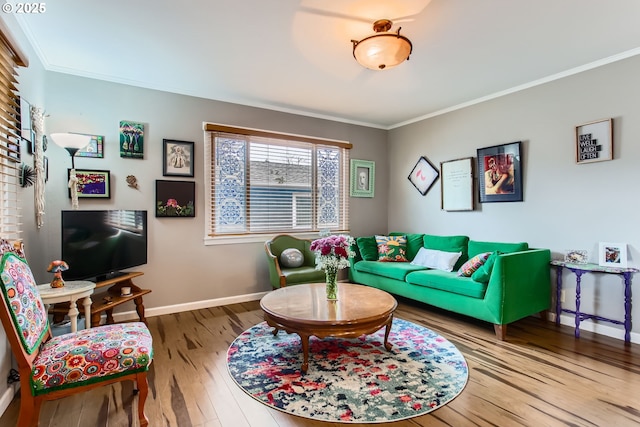 living area with baseboards, hardwood / wood-style floors, and crown molding