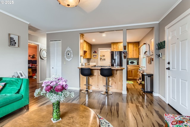 interior space with crown molding, baseboards, and light wood-type flooring