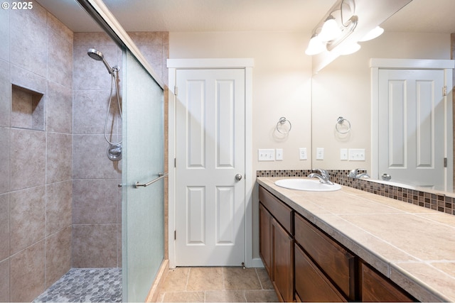 bathroom featuring a shower stall and vanity