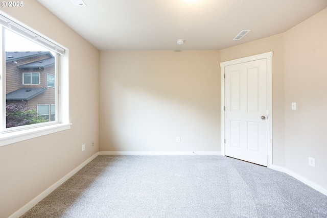 carpeted spare room featuring baseboards