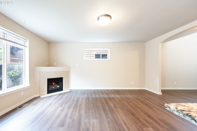 unfurnished living room with wood finished floors, a fireplace, and baseboards