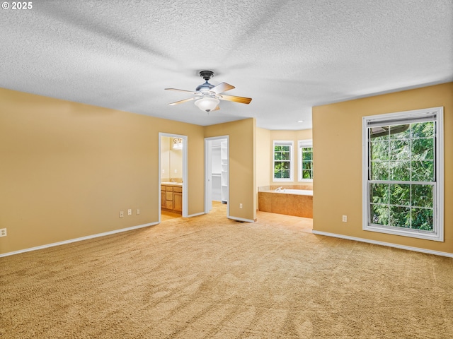 14300 Sherbrook Pl, Lake Oswego, OR 97035 - unfurnished bedroom with a walk in closet, light colored carpet, connected bathroom, baseboards, and a textured ceiling
