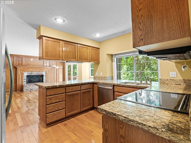 14300 Sherbrook Pl, Lake Oswego, OR 97035 - kitchen featuring a sink, stainless steel appliances, brown cabinets, a peninsula, and light wood-style flooring