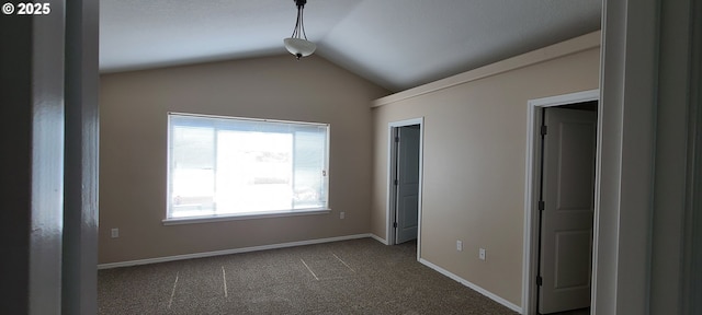 unfurnished bedroom featuring dark colored carpet and vaulted ceiling