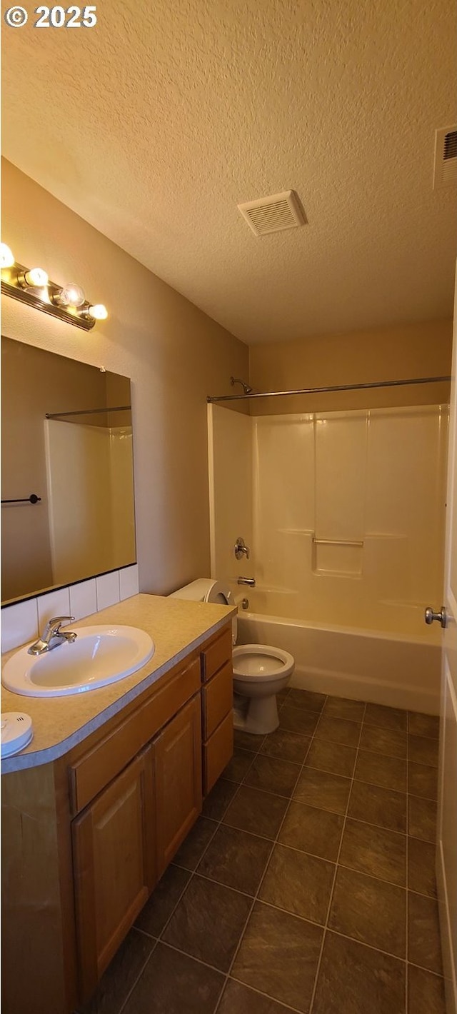 full bathroom featuring shower / washtub combination, vanity, toilet, tile patterned floors, and a textured ceiling