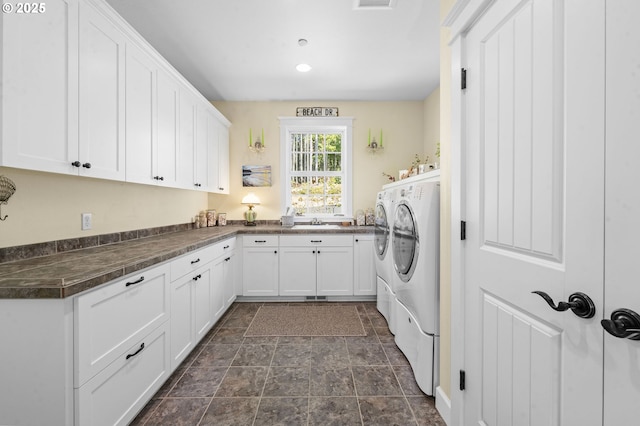 33525 Beerman Creek Ln, Seaside, OR 97138 - laundry room with washing machine and clothes dryer, cabinet space, and dark stone finish flooring
