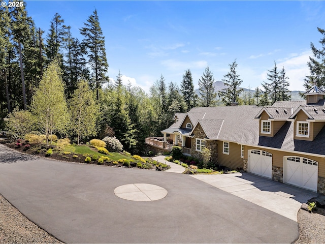33525 Beerman Creek Ln, Seaside, OR 97138 - shingle-style home with stone siding, driveway, a garage, a shingled roof, and a chimney