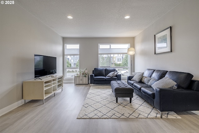 living room featuring recessed lighting, a textured ceiling, and wood finished floors
