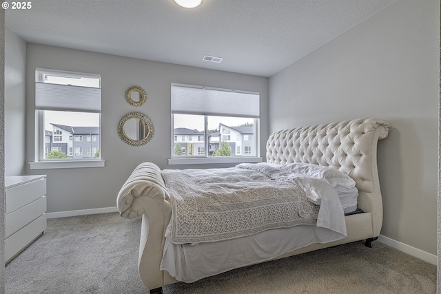 carpeted bedroom featuring baseboards and visible vents