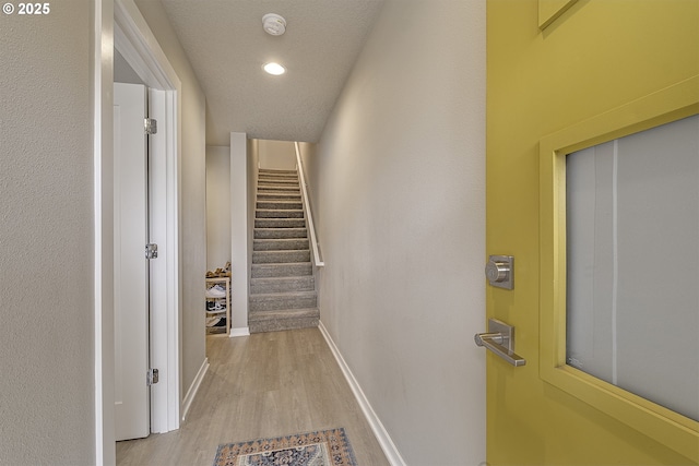hallway with recessed lighting, baseboards, light wood-type flooring, and stairs