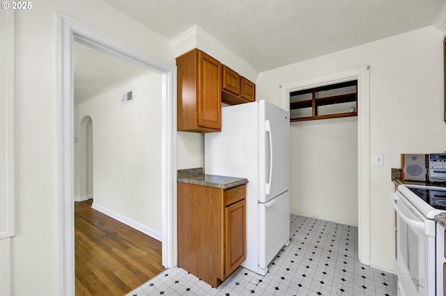 2674 Kincaid St, Eugene, OR 97405 - kitchen featuring brown cabinets, white appliances, arched walkways, and dark countertops