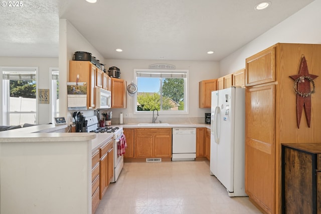 302 NW Elderberry Ln, Dallas, OR 97338 - kitchen featuring white appliances, light countertops, light flooring, recessed lighting, and a peninsula