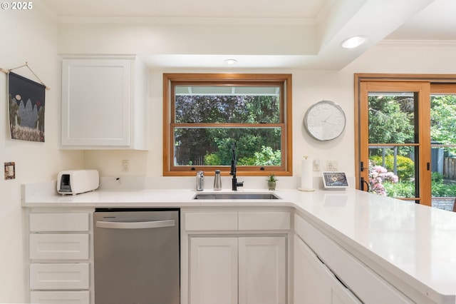 kitchen with stainless steel dishwasher, a sink, white cabinetry, light countertops, and crown molding