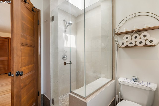 bathroom with a tile shower and toilet
