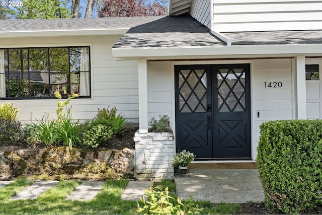 doorway to property with roof with shingles