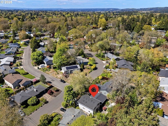 aerial view of property's location with nearby suburban area and a heavily wooded area