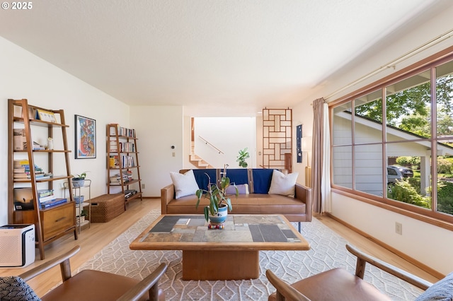 living area featuring wood finished floors, stairway, and baseboards