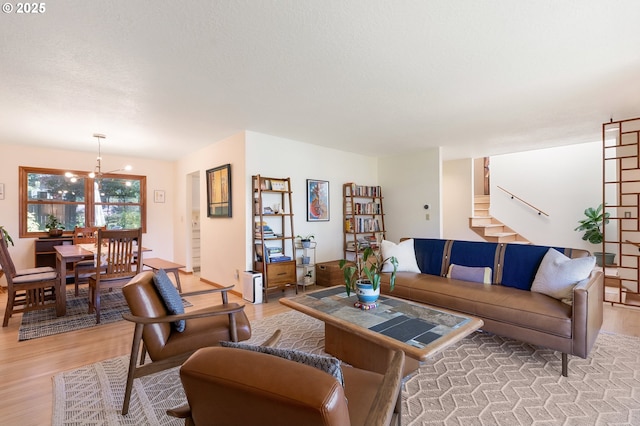 living area featuring light wood-style floors, stairs, and a chandelier