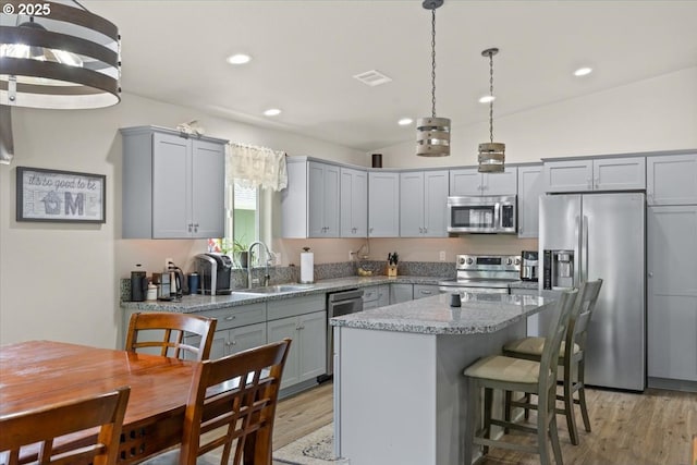 kitchen featuring stainless steel appliances, gray cabinets, a sink, and recessed lighting