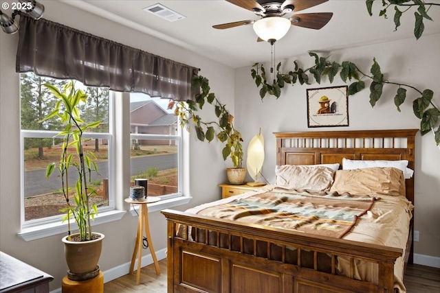 bedroom featuring light wood-style floors, baseboards, and a ceiling fan