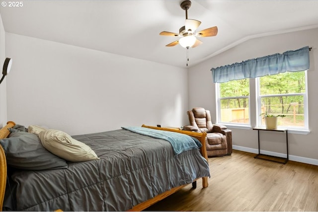 bedroom with lofted ceiling, wood finished floors, baseboards, and ceiling fan