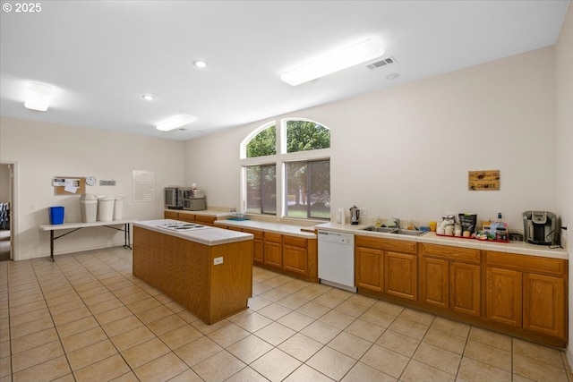 kitchen featuring white appliances, tile counters, a sink, light tile patterned flooring, and a kitchen island