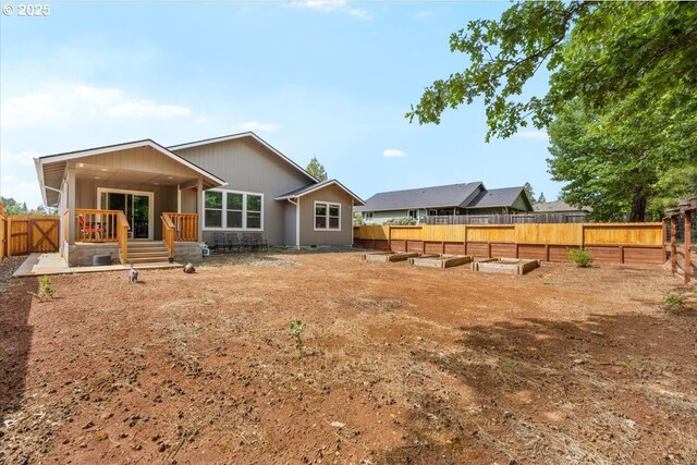 371 Cedar, Cave Junction, OR 97523 - back of house featuring a vegetable garden and a fenced backyard