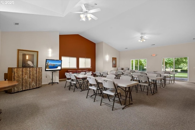 dining area featuring a ceiling fan, carpet, and high vaulted ceiling
