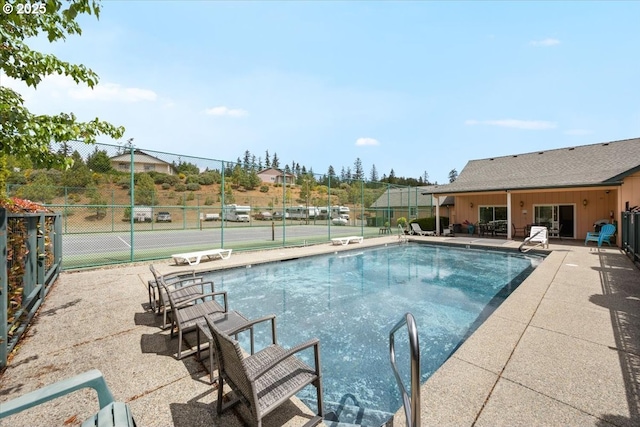 community pool featuring fence and a patio
