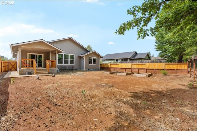 back of property with a garden and a fenced backyard