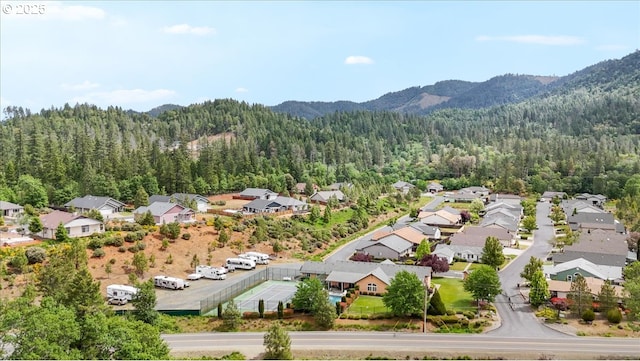 aerial perspective of suburban area with a heavily wooded area and mountains