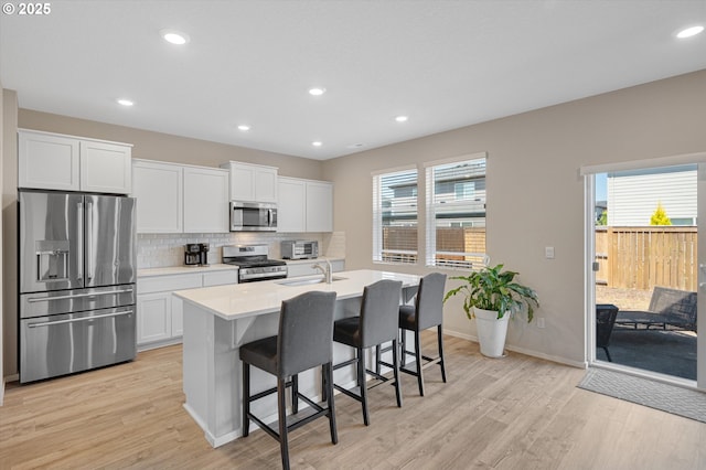 4829 Surveyor Ave, Salem, OR 97305 - kitchen with appliances with stainless steel finishes, light wood-style floors, backsplash, white cabinets, and recessed lighting