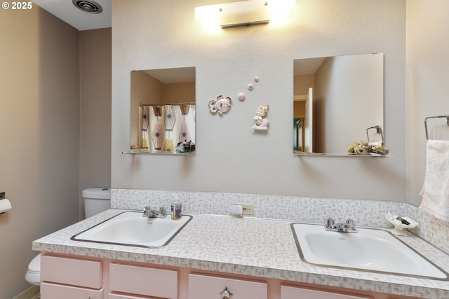 bathroom featuring vanity and toilet