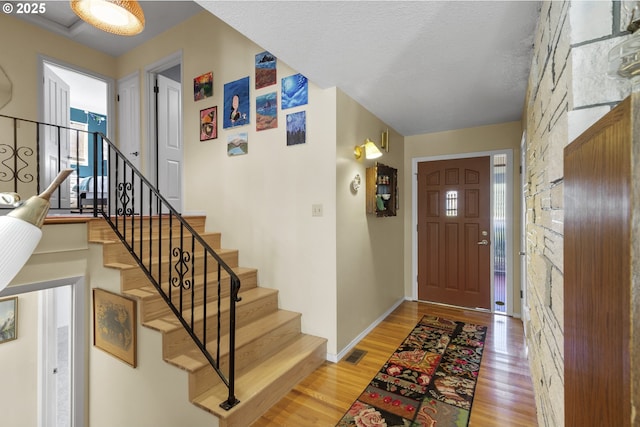 foyer entrance featuring hardwood / wood-style flooring and a textured ceiling