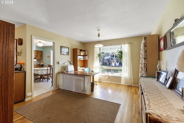 dining room with a textured ceiling and light wood-type flooring