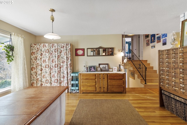 kitchen featuring plenty of natural light, decorative light fixtures, a mail area, and light wood-type flooring