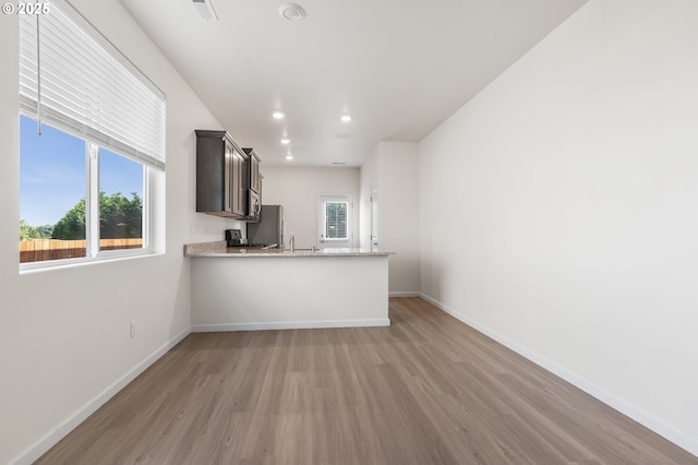 1712 W 12th St, La Center, WA 98629 - kitchen featuring freestanding refrigerator, light wood finished floors, baseboards, a peninsula, and recessed lighting