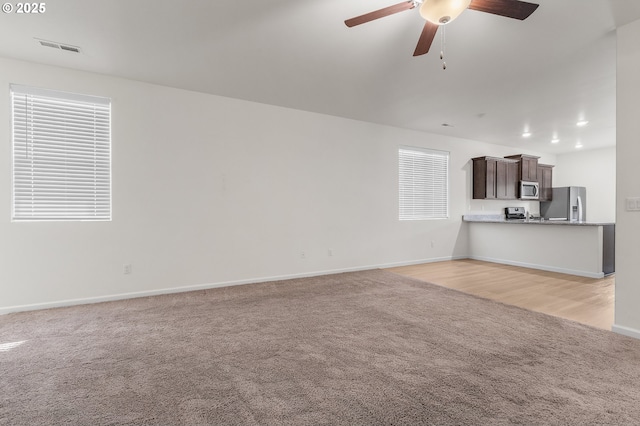 1712 W 12th St, La Center, WA 98629 - unfurnished living room with light carpet, a ceiling fan, and baseboards