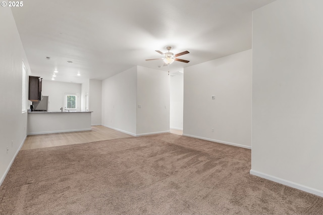 1712 W 12th St, La Center, WA 98629 - unfurnished living room featuring ceiling fan, light carpet, and baseboards