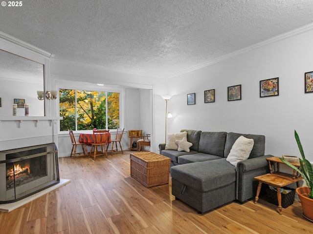 living room featuring crown molding, a textured ceiling, and light wood-type flooring