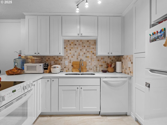 kitchen with decorative backsplash, white appliances, white cabinetry, and sink