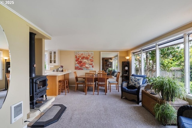 1745 Pearl St, Tillamook, OR 97141 - living area featuring healthy amount of natural light, a wood stove, carpet flooring, and heating unit