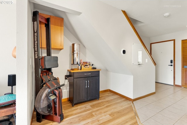 additional living space featuring baseboards and light wood finished floors