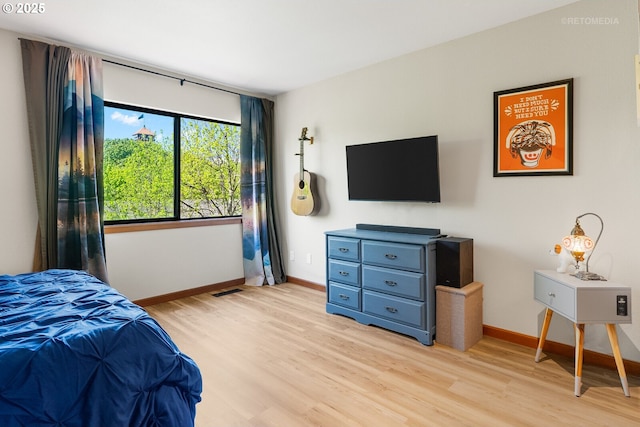 bedroom featuring light wood-type flooring, visible vents, and baseboards
