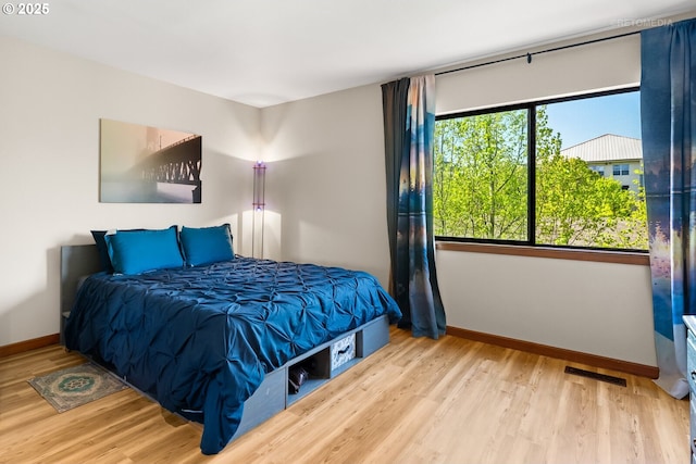 bedroom featuring visible vents, wood finished floors, and baseboards