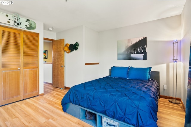 bedroom featuring wood finished floors, a closet, and baseboards